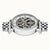 Herrenuhr im schrägen Blick: skelettiertes Zifferblatt, sichtbare Mechanik und Metallarmband