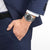 Montre bracelet en acier au poignet avec cadran et aiguilles noirs