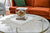 Horloge de table dans un boîtier en verre transparent avec cadran rond sur un socle blanc