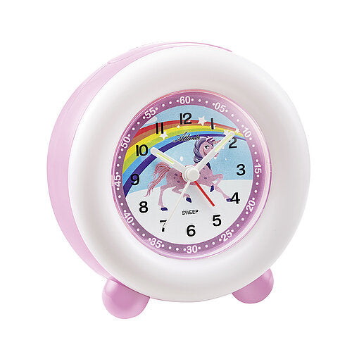 Réveil enfant rose avec cadran rond, motif coloré et aiguilles blanches.