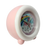 Réveil enfant sur le côté, boîtier rose/blanc avec cadran rond en détail.
