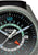 Uhr-Detail mit silberner Lünette, dunklem Zifferblatt, Leuchtindizes und GMT