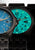 Zwei Herrenarmbanduhren im Vergleich: blaues und grünes Zifferblatt mit schwarzen Armbändern