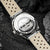 Montre DS9 de Holzkern avec fond de boîtier transparent, gravure périphérique et bracelet en cuir gris clair