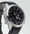 Montre homme dans un boîtier argenté avec bracelet noir et cadran noir de profil