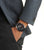 Chronographe pour homme au poignet : cadran sombre avec accents rouges et bracelet en métal.