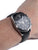 Festina Herrenuhr am Handgelenk: schwarzes Zifferblatt und schwarzes Lederarmband