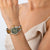 Montre pour femme au poignet avec cadran vert et bracelet en acier inoxydable or-argent