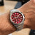 Festina Chronograph-Herrenuhr am Handgelenk: rotes Zifferblatt, Edelstahlarmband, Drücker