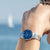 Montre pour femme au poignet avec cadran bleu, bracelet en métal argenté et aiguilles