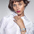Montre pour femme au poignet d'une femme avec une chemise blanche, bracelet en acier inoxydable
