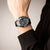 Montre chronographe pour homme au poignet avec bracelet camouflage noir et chronographe