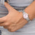 Montre pour femme au poignet avec bracelet en métal argenté et cadran rose