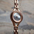 Damenarmbanduhr mit roséfarbenem Gehäuse und blauem Zifferblatt, seitliche Ansicht des Armbands