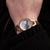 Damenarmbanduhr mit roséfarbenem Gehäuse, blauem Zifferblatt und Gliederarmband am Handgelenk