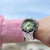 Montre pour homme en acier inoxydable au poignet avec cadran vert et lunette noire