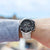 Montre de sport pour homme au poignet avec cadran noir et bracelet en métal