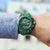 Chronographe de sport pour homme au poignet : cadran vert et bracelet en métal vert.