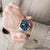Herrenarmbanduhr am Handgelenk mit blauem Zifferblatt und Stahlband