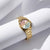 Goldfarbene Damenarmbanduhr mit Metallband und blau-grün schimmerndem Zifferblatt