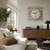 Wanduhr mit rundem Zifferblatt im Holzrahmen über Sideboard im Wohnbereich
