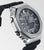 Montre homme de profil : boîtier métallique argenté, bracelet et boutons noirs.