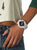 Montre blanche pour femme au poignet avec bracelet blanc et cadran noir