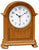 Horloge de table en bois avec boîtier bombé, cadran blanc et aiguilles noires.
