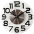 Horloge murale ronde avec cadran blanc, chiffres noirs et aiguilles noires