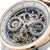 Herrenuhr Nahaufnahme: skelettiertes Zifferblatt mit Mondphase, dunkelblauen Akzenten und roséfarbenen Linien.