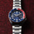 Herrenuhr mit blauem Zifferblatt, Pepsi-Lünette, Schieberkrone und Edelstahlband