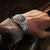 Seiko Herrenuhr am Handgelenk mit schwarzem Zifferblatt und Edelstahlarmband