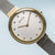 Montre pour femme avec inscription BERING, cadran blanc, lunette dorée et bracelet milanais