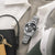 Edelstahlarmbanduhr am Handgelenk mit schwarzem Zifferblatt, Chronograph und silbernem Metallarmband.