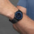 Montre pour homme au poignet : cadran bleu et bracelet en maille noire