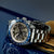 Herrenuhr mit Metallarmband, schwarzem Chronographen-Zifferblatt und blauer Tachymeter-Lünette