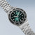 Bracelet de montre pour homme, vue latérale, avec cadran vert, bracelet en acier inoxydable argenté