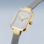 Montre femme avec cadran rectangulaire argenté et lunette dorée, bracelet milanais