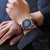 Montre bracelet pour homme au poignet avec cadran bleu et bracelet en cuir marron