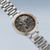 Montre bracelet pour homme en vue oblique : bracelet en titane, cadran noir avec accents orange