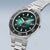 Bracelet de montre pour homme, vue de face, avec cadran vert soleillé, lunette noire et bracelet en métal