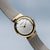 Montre pour femme avec bracelet milanais argenté, lunette dorée et cadran blanc