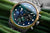 Montre femme avec cadran vert, chronographe et boutons-poussoirs, bracelet en acier inoxydable