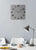 Horloge murale sur un mur avec un cadran carré et des aiguilles