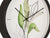 Wanduhr Detailansicht: botanische Blätter, schwarze Zeiger im schwarzen Rundrahmen