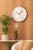 Horloge murale ronde avec cadran blanc et aiguilles des heures et des minutes rouge corail