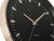 Wanduhr-Zifferblatt: schwarzer Hintergrund mit weißen Indexstrichen und silbernen Zeigern