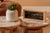 Réveil analogique rectangulaire avec cadre en bambou sur une table d'appoint, cadran avec température et humidité