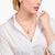 Collier doré avec pendentif goutte sur le décolleté