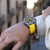 Montre chronographe pour homme au poignet avec bracelet jaune et cadran noir